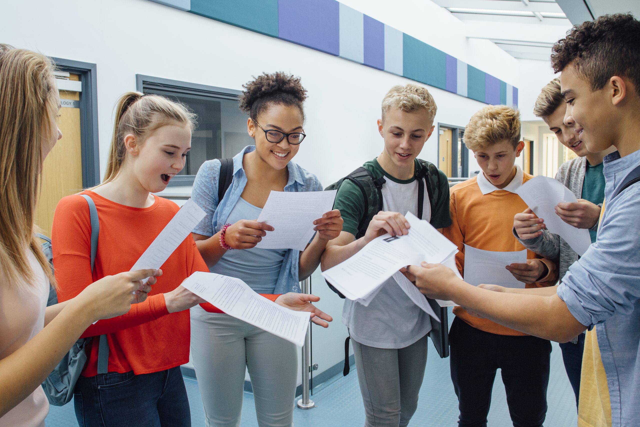 Happy students have received their exam results in high school. They are cheering and celebrating.